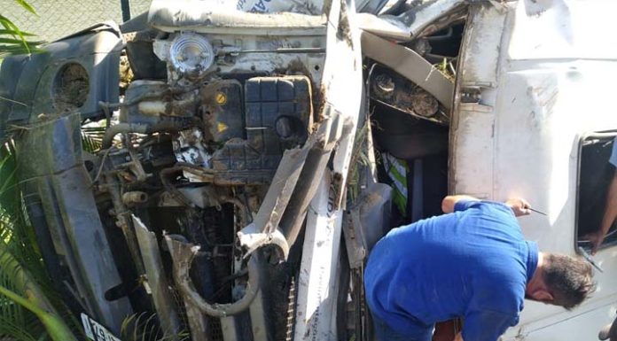 Caçamba tomba fora da pista e homem fica com as pernas presas às ferragens