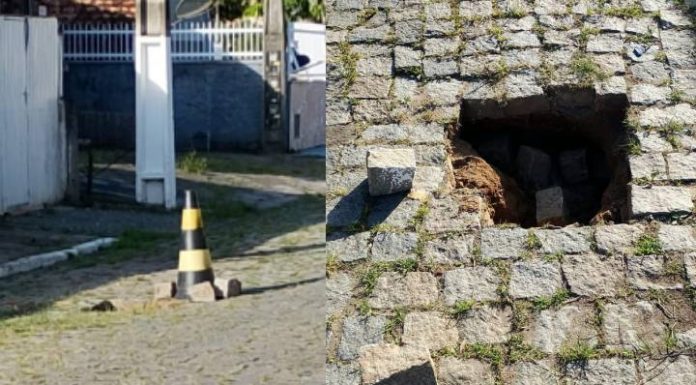 VERGONHA Morador improvisa sinalização após buraco se abrir em rua no centro de Piçarras