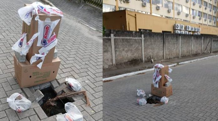 Moradores improvisam sinalização com caixas e sacolas para alertar sobre buracos em rua de Piçarras